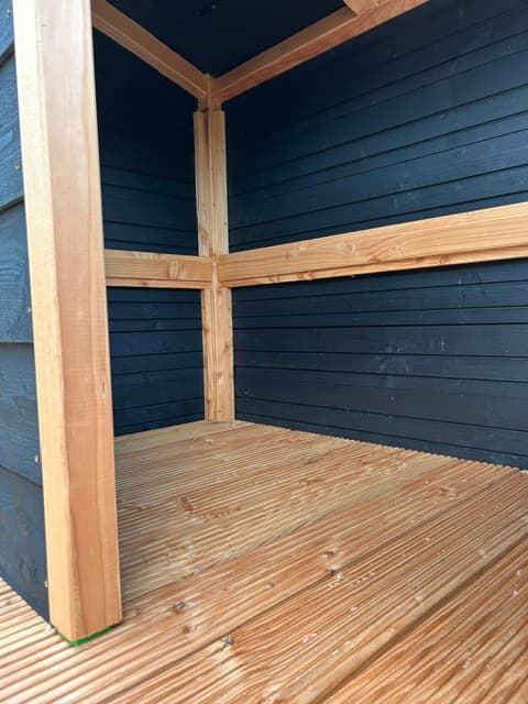 Detail van de stevige houtconstructie en donkerblauwe wand
