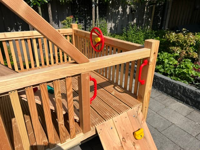 Veranda met houten hekwerk en rode handgrepen