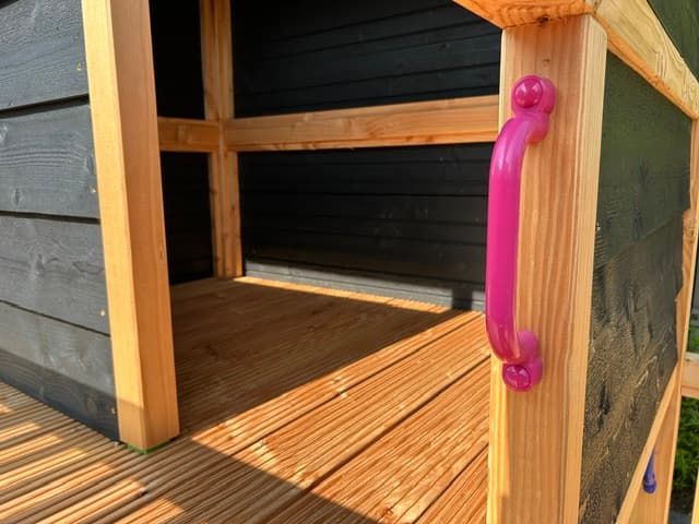 Binnenkant van het speeltoestel met een roze handgreep