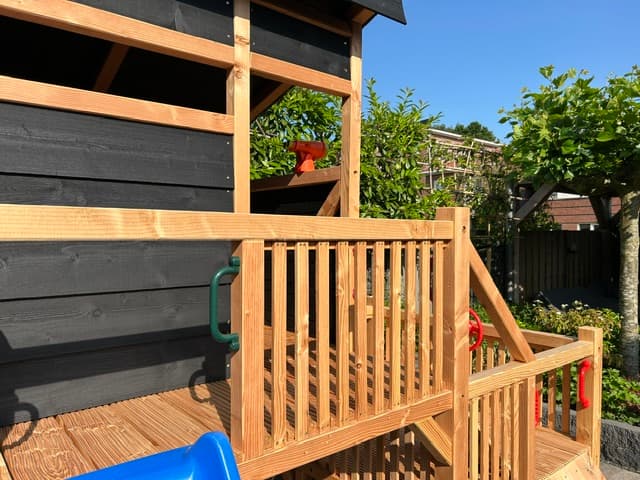 Houten veranda met trapleuning van het speeltoestel